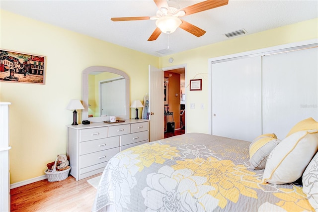 bedroom featuring ceiling fan, a closet, and light hardwood / wood-style flooring