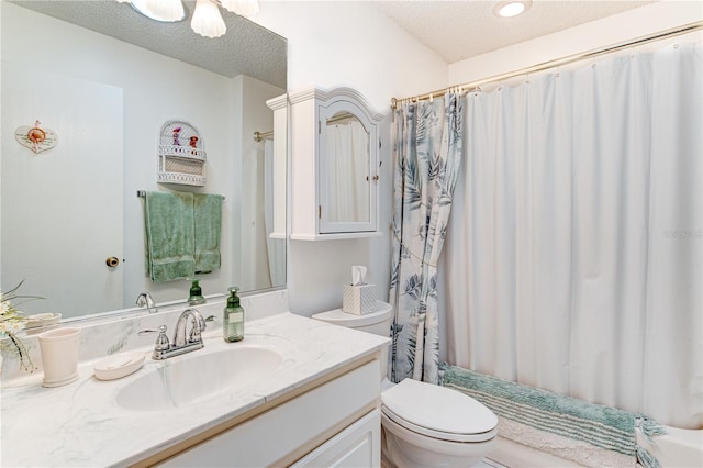 bathroom featuring toilet, a textured ceiling, and vanity