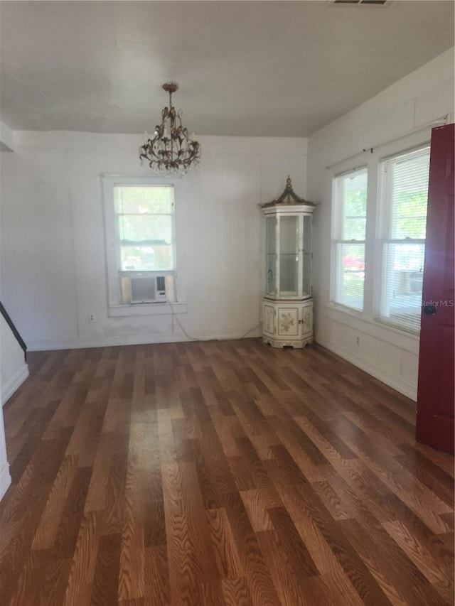 unfurnished living room featuring dark hardwood / wood-style floors and a notable chandelier