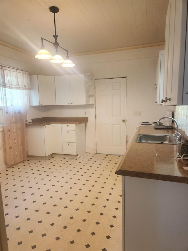 kitchen with crown molding, light tile floors, pendant lighting, and white cabinetry