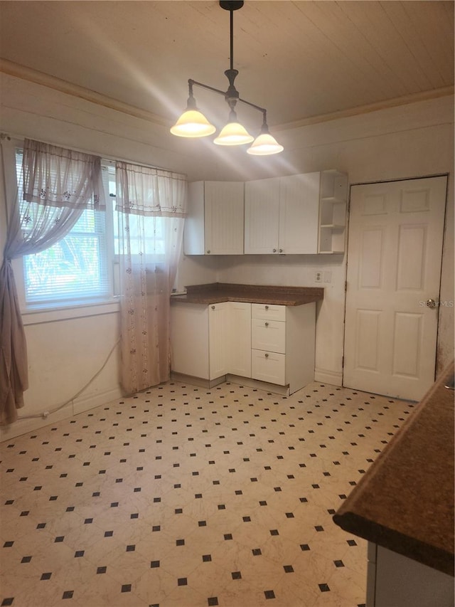 kitchen featuring decorative light fixtures, light tile flooring, and crown molding