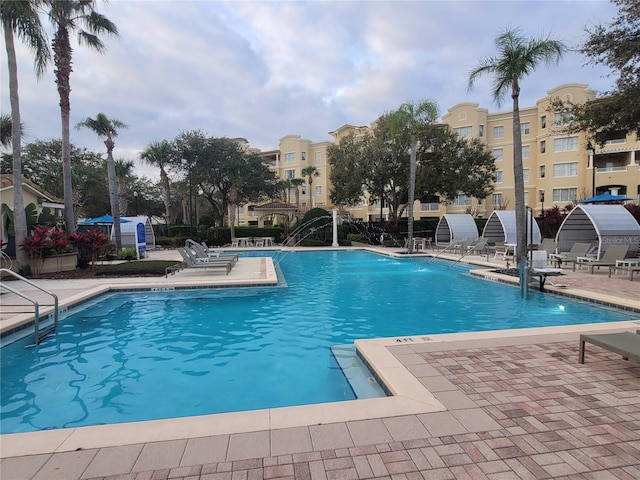 view of swimming pool with pool water feature and a patio