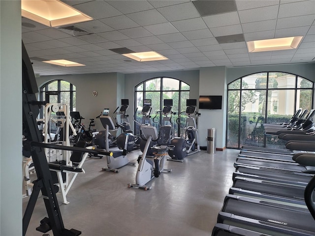 gym with a drop ceiling and a wealth of natural light