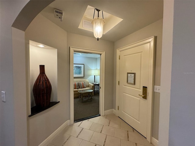 entryway with light carpet and a tray ceiling