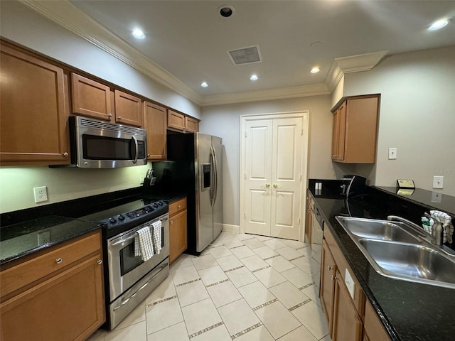 kitchen featuring stainless steel appliances, light tile floors, dark stone counters, crown molding, and sink