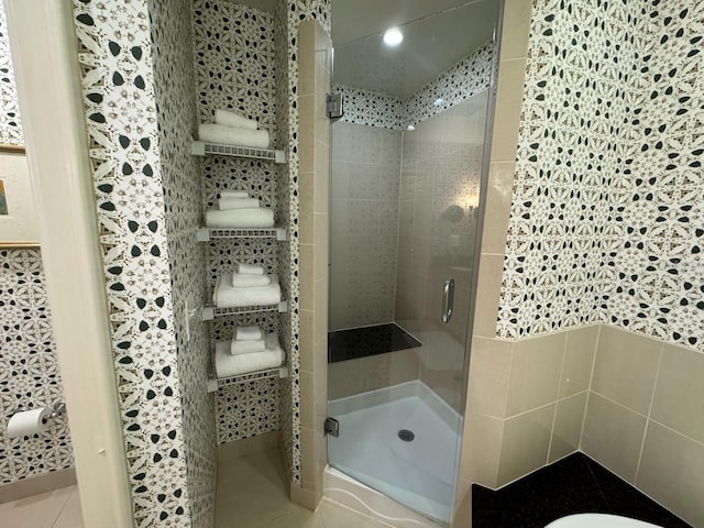 bathroom with tile walls, tile floors, and an enclosed shower