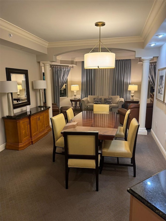 dining space featuring ornamental molding, dark colored carpet, and ornate columns