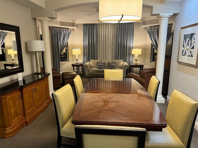 carpeted dining area with ornamental molding, decorative columns, and ceiling fan