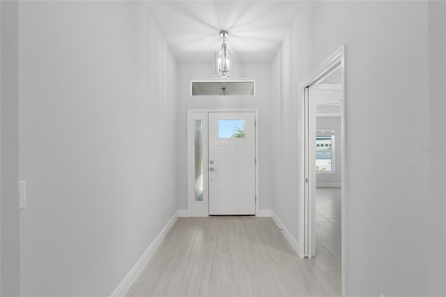 entryway with a textured ceiling and light tile patterned floors