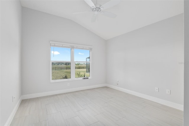 spare room featuring ceiling fan, light tile patterned flooring, and vaulted ceiling