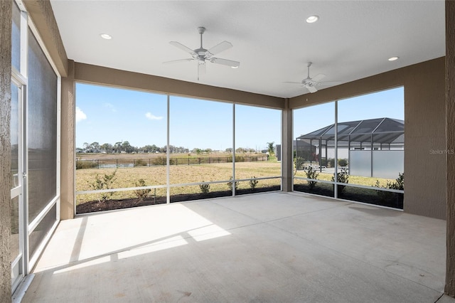 unfurnished sunroom featuring ceiling fan and a healthy amount of sunlight