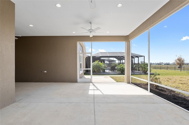 unfurnished sunroom featuring ceiling fan