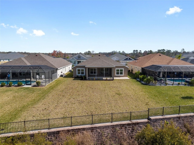 rear view of property with a lanai and a yard