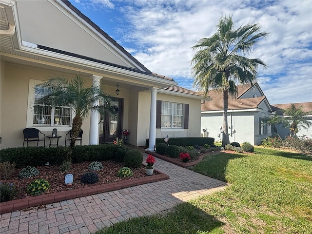 view of exterior entry featuring a lawn