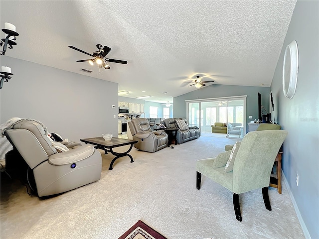 carpeted living room featuring vaulted ceiling, ceiling fan, and a textured ceiling