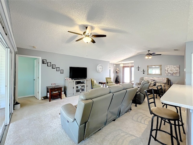 living room with light carpet, vaulted ceiling, ceiling fan, and a textured ceiling