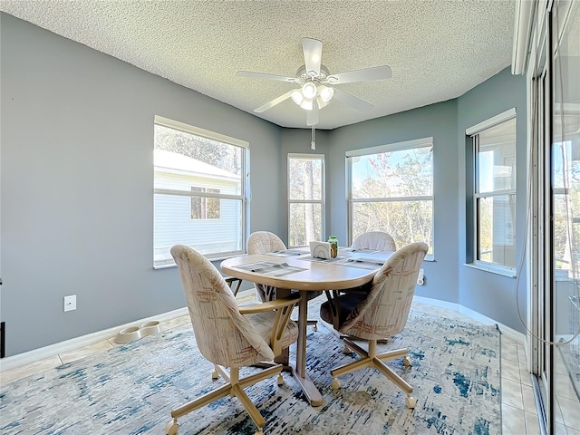 dining area with ceiling fan, a healthy amount of sunlight, and light tile flooring