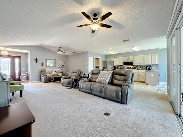 living room with light carpet, lofted ceiling, ceiling fan, and a textured ceiling