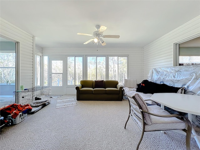 living room featuring a healthy amount of sunlight, ceiling fan, and light colored carpet