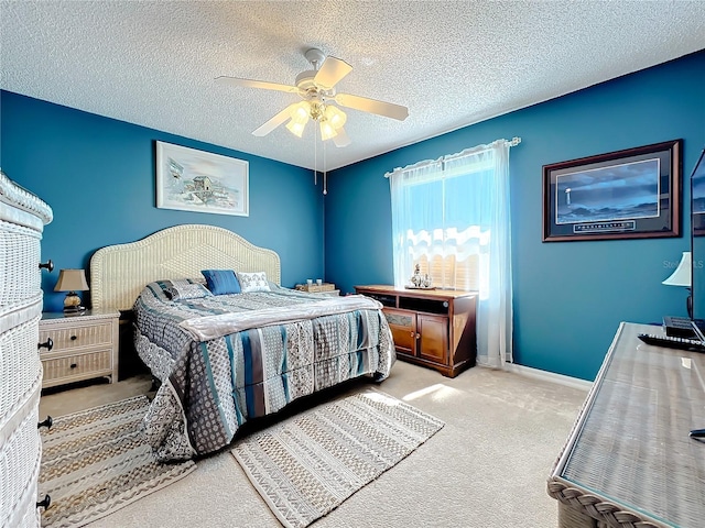 carpeted bedroom featuring ceiling fan and a textured ceiling