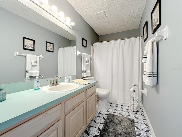 bathroom with vanity, tile flooring, a textured ceiling, and toilet