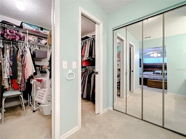 interior space with ceiling fan and light colored carpet