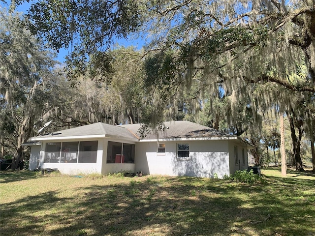 rear view of house with a sunroom and a yard