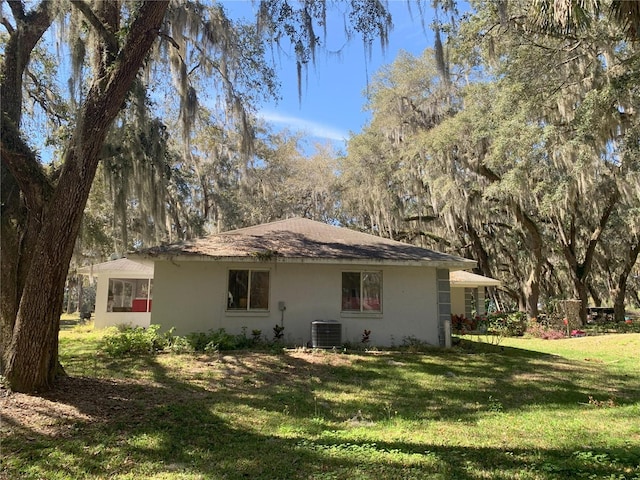 back of house featuring a lawn and central AC unit