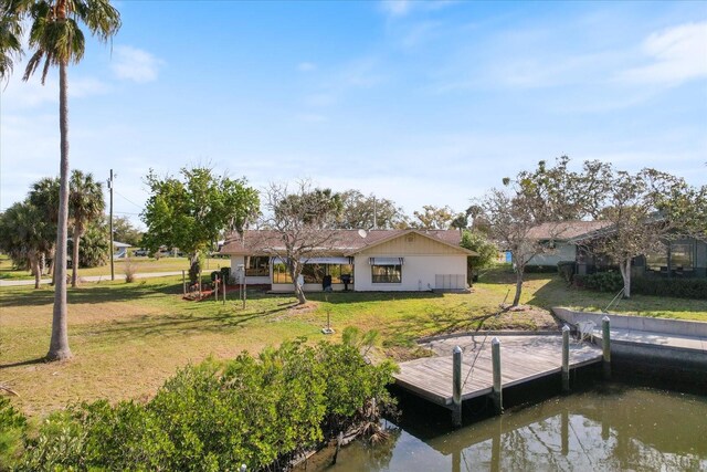 view of dock featuring a water view and a yard