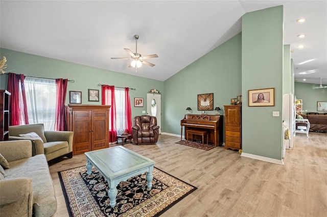 living room with high vaulted ceiling, ceiling fan, and light wood-type flooring