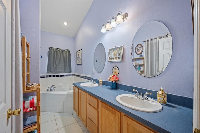 bathroom featuring tiled tub, tile floors, dual sinks, and large vanity