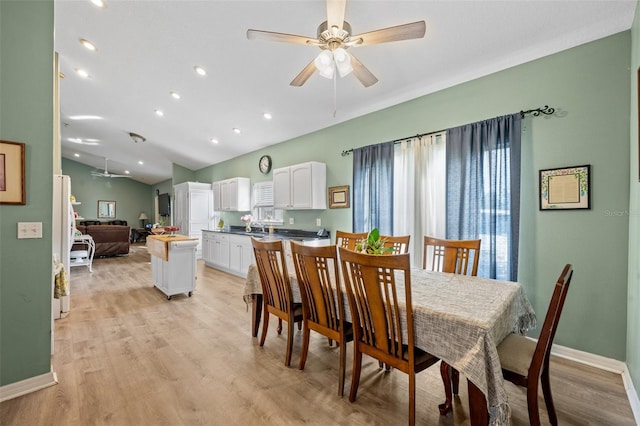 dining area with light hardwood / wood-style floors, ceiling fan, and lofted ceiling