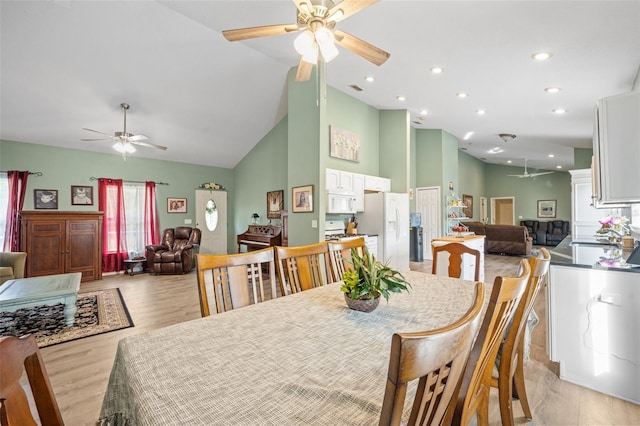 dining area featuring high vaulted ceiling, ceiling fan, and light hardwood / wood-style flooring