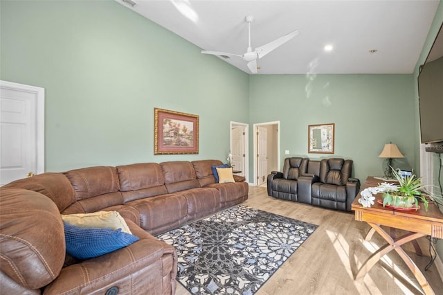 living room featuring high vaulted ceiling, ceiling fan, and light wood-type flooring