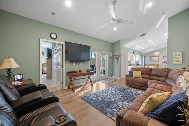 living room featuring light hardwood / wood-style floors, vaulted ceiling, ceiling fan, and french doors