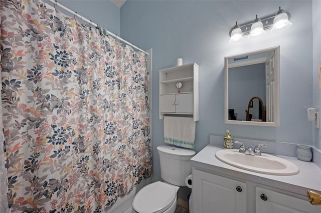 bathroom with toilet and vanity with extensive cabinet space