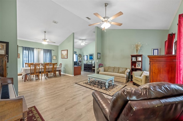 living room with high vaulted ceiling, ceiling fan, and light hardwood / wood-style flooring