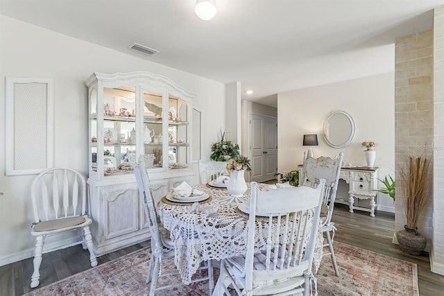 dining area with wood finished floors, visible vents, and baseboards