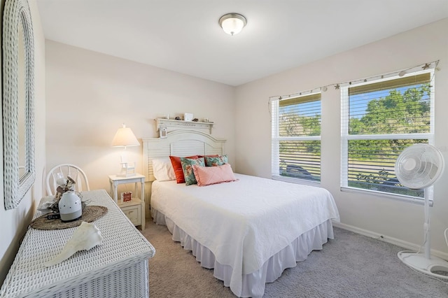 bedroom with light carpet and baseboards