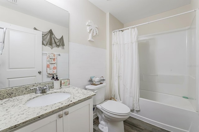 full bathroom with hardwood / wood-style flooring, toilet, tile walls, shower / tub combo with curtain, and vanity