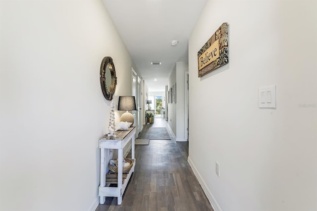 hallway featuring baseboards and dark wood-style flooring