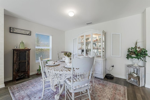 dining area featuring visible vents, baseboards, and wood finished floors