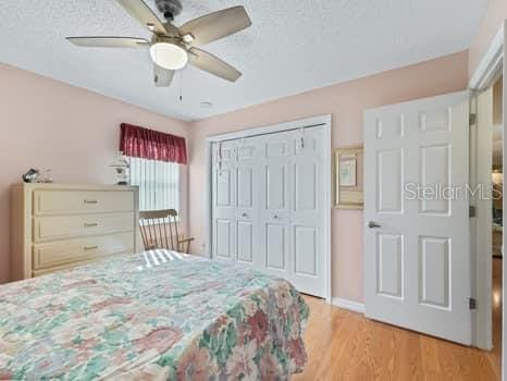 bedroom featuring light hardwood / wood-style floors, a closet, and ceiling fan