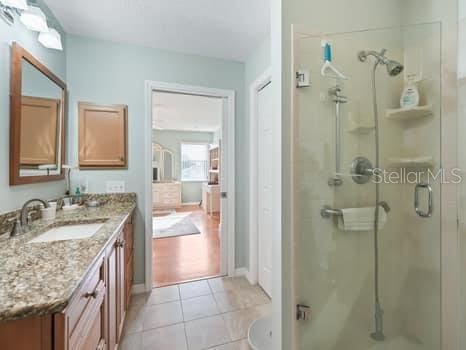 bathroom with tile floors, an enclosed shower, and vanity