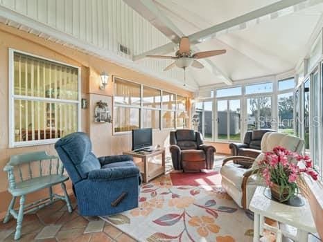 sunroom with ceiling fan and lofted ceiling with beams