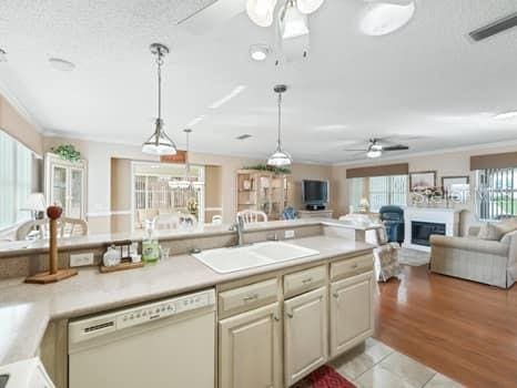 kitchen featuring ceiling fan, sink, pendant lighting, dishwasher, and ornamental molding