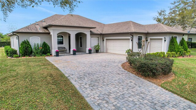 ranch-style house featuring a front yard and a garage