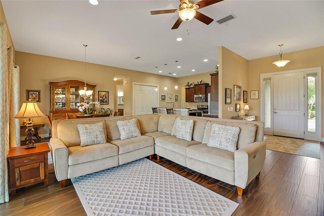 living room with dark wood-type flooring and ceiling fan