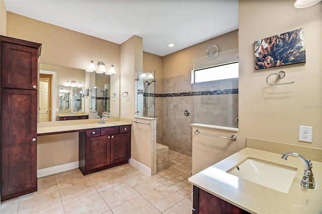 bathroom featuring tiled shower, vanity, and tile flooring