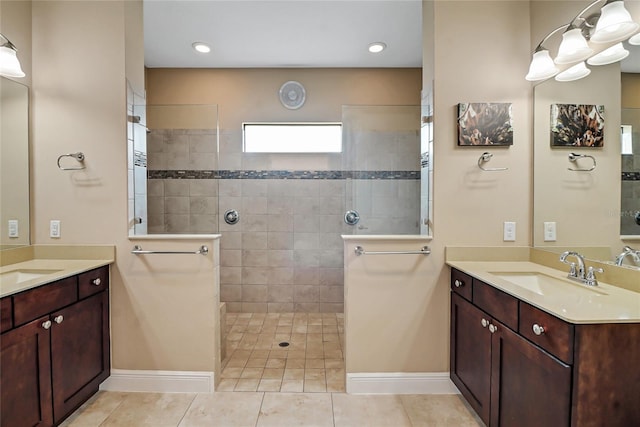 bathroom featuring tile floors, tiled shower, and double sink vanity